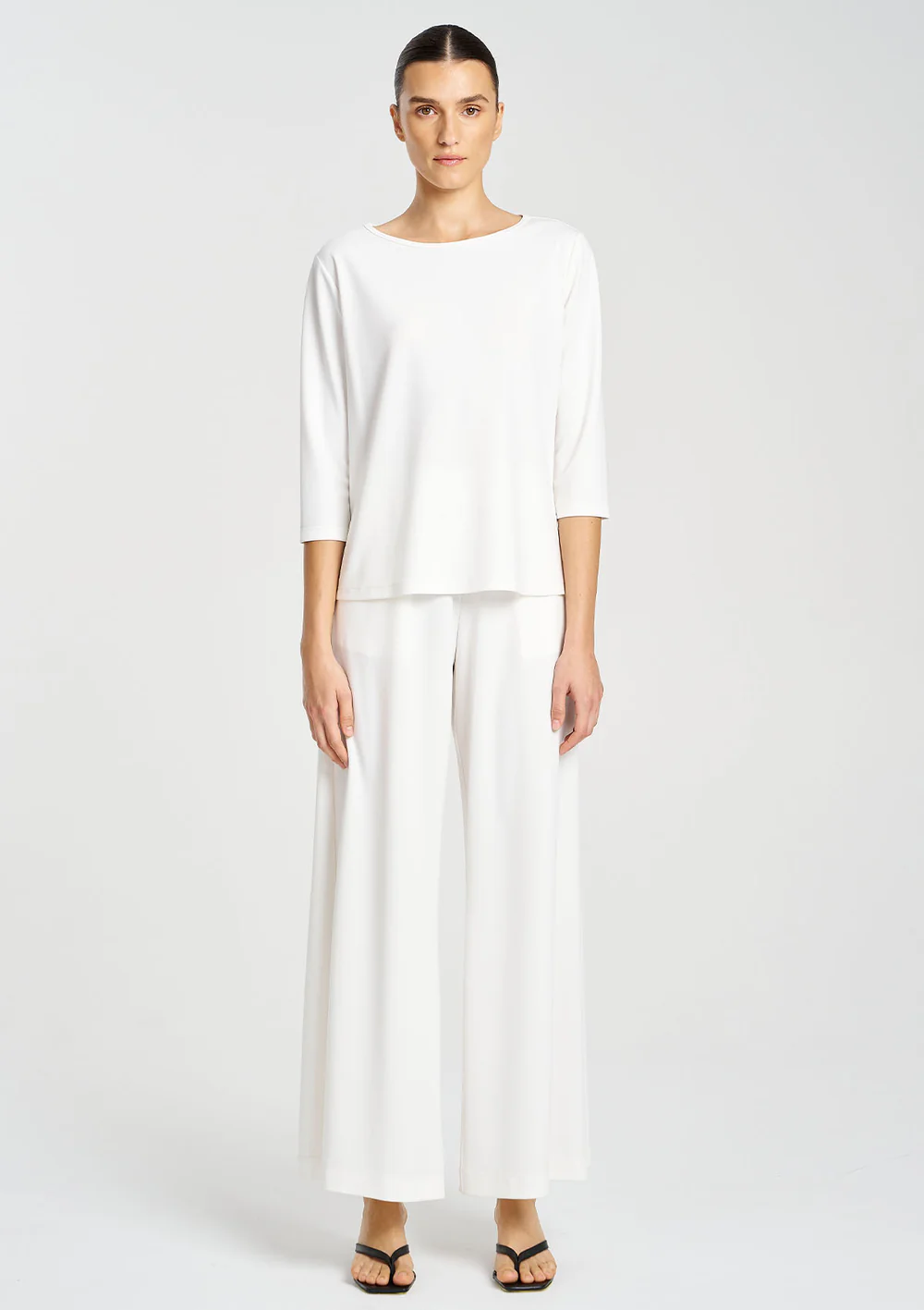 Woman wearing a white outfit on a plain background